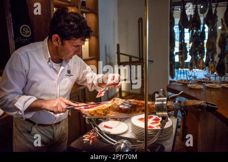 Professional ham slicer. Cinco Jotas factory iberian ham cellar Jabugo village, Huelva province, Region of Andalusia, Spain.  Jabugo is internationall Stock Photo