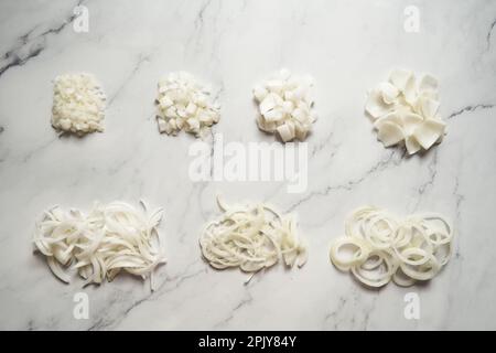 Different cuts of onions. Photo show different onion cuts from small to large dice, rings, chunks and half moon slice plus julienne Stock Photo