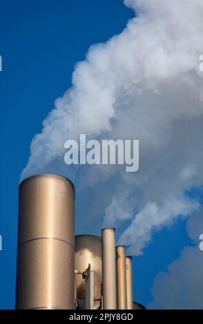 Smoke billowing from metal chimneys Stock Photo