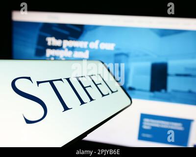 Smartphone with logo of US investment company Stifel Financial Corp. on screen in front of website. Focus on center-left of phone display. Stock Photo