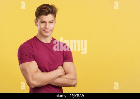 Strong man smiling at the camera with arms crossed Stock Photo