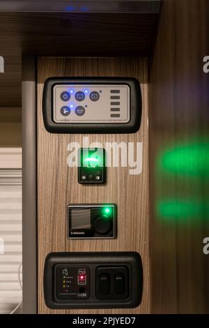 Control panel in a campervan showing electrics, water pump switch, LPG gas control, Webasto diesel heater and water tank. UK Stock Photo