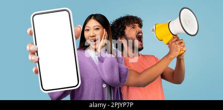 Asian Woman And Indian Man Using Loudspeaker And Showing Big Blank Smartphone Stock Photo