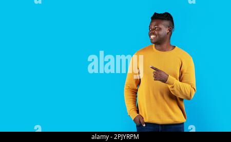 Handsome Black Man Pointing Aside At Copy Space With Hand Stock Photo