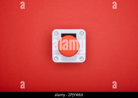 Single emergency button at the red background at the top view Stock Photo