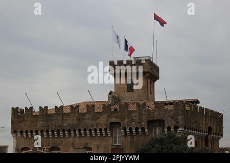 Château Grimaldi in Haut de Cagnes town square seen on an overcast day in winter flying flags of France and Cagnes-sur-Mer (Cagnes sur Mer, France) Stock Photo
