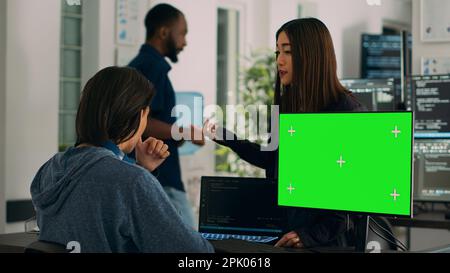 Asian IT engineers analyzing greenscreen on computer and coding database program with html script. Using mockup template with isolated copyspace and chromakey, programming code. Stock Photo