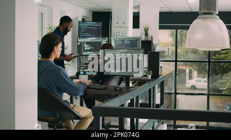 Male software developer typing machine learning app code on computer, sitting at desk in big data office. Cloud programer working on database system with html script in it security agency. Stock Photo