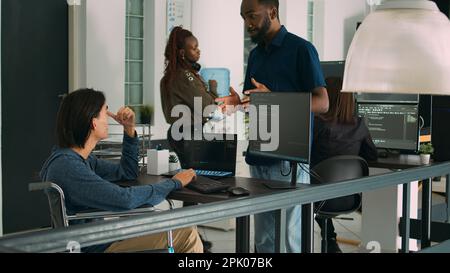 Asian software developer with chronic disability working on server coding, analyzing html language and script on terminal window. Wheelchair user with impairment working on it system. Stock Photo