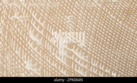 Abstract embossed rough stone background in beige color with white spots Stock Photo
