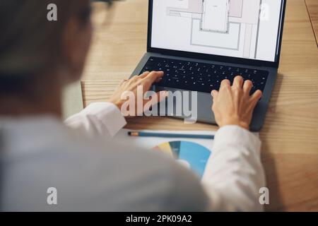 Close up of woman architect creating new project on laptop while sit on the office desk Stock Photo