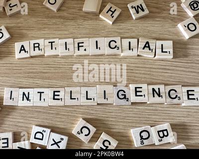 The word Artificial Intelligence spelled out in letter game pieces on a light wooden background Stock Photo