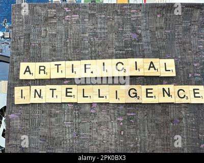 The word Artificial Intelligence spelled out in letter game pieces on a computer motherboard with fuax leather background Stock Photo