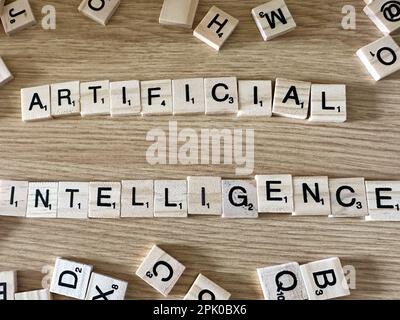The word Artificial Intelligence spelled out in letter game pieces on a light wooden background Stock Photo