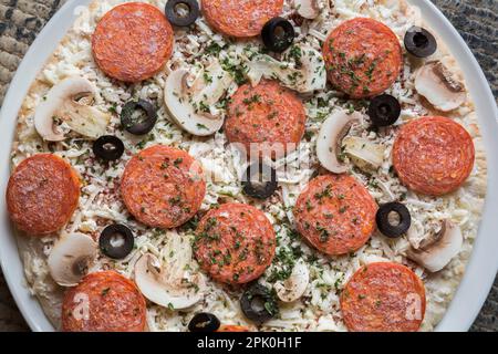 Frozen pepperoni and cheese pizza with black olives and white mushrooms, Studio Composition, Quebec, Canada Stock Photo
