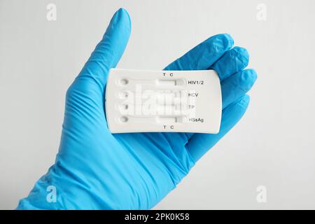 Doctor holding disposable express test for hepatitis on white background, closeup Stock Photo