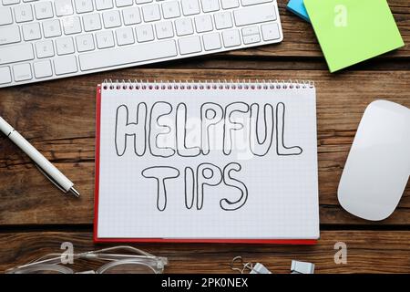 Flat lay composition with text Helpful Tips in notebook on wooden table Stock Photo