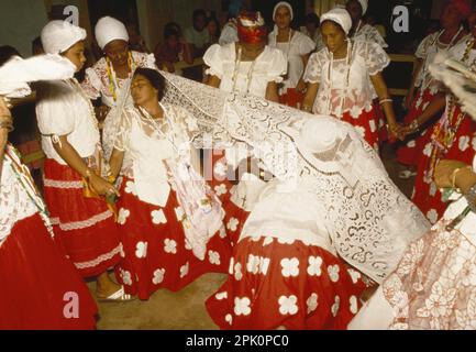 Tambor de Mina, syncretic Afro-Brazilian spirit possession religion. Two cult members (filhas de santo) in trance are covered with a ritual cloth Stock Photo