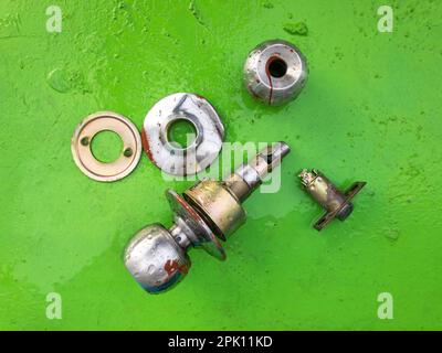 Broken door knob isolated on a green background Stock Photo