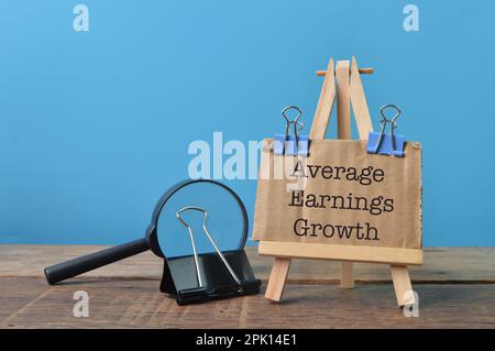 Brown card written with text AVERAGE EARNINGS GROWTH Stock Photo