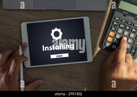 man installing Software Update On Mobile Phone And Laptop digital technology communication Stock Photo