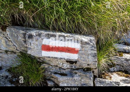 Hiking trails marker on the Swiss Alps by a red and white bars indicates more challenging routes. These signs are set by the Swiss Hiking Association. Stock Photo