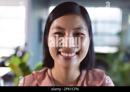 Portrait of happy asian businesswoman looking at camera and smiling at office Stock Photo