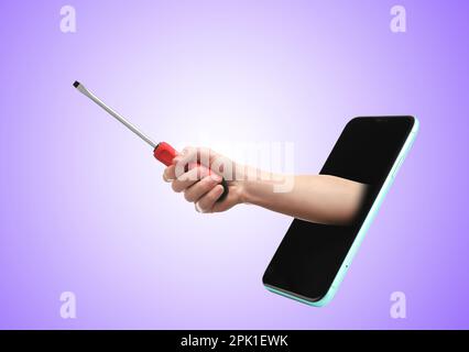 Repair service - just call. Closeup view of man with screwdriver and smartphone on violet background Stock Photo