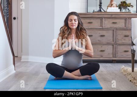 All the strength I need is within me. a pregnant young woman meditating at home. Stock Photo