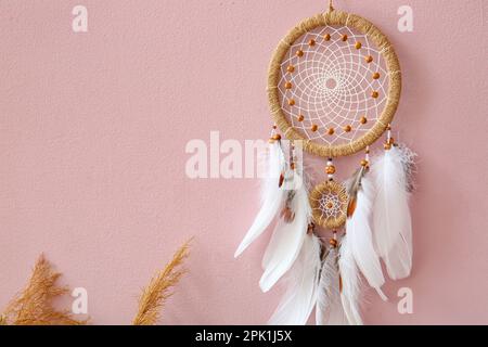 Dream catcher hanging on pink wall Stock Photo