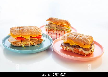 Three ciabatta sandwiches served on  plates Stock Photo