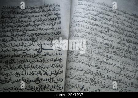 Close up, detailed view of pages of a koran, featuring beautiful, handwritten script, arabic text. At the Emirates Heritage Club Heritage Village in A Stock Photo