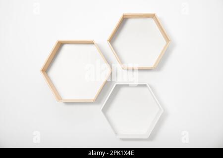 Empty honeycomb shaped shelves on white wall Stock Photo