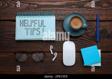 Flat lay composition with text Helpful Tips in notebook on wooden table Stock Photo
