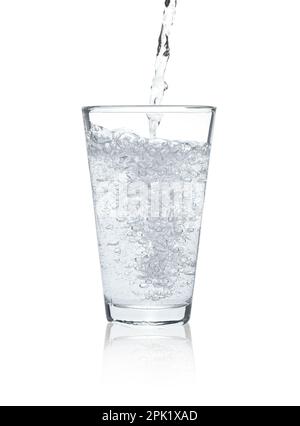 Pouring soda water into glass on white background Stock Photo