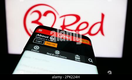 smartphone-with-website-of-online-casino-company-32red-limited-on-screen-in-front-of-business-logo-focus-on-top-left-of-phone-display-2pk224h.jpg