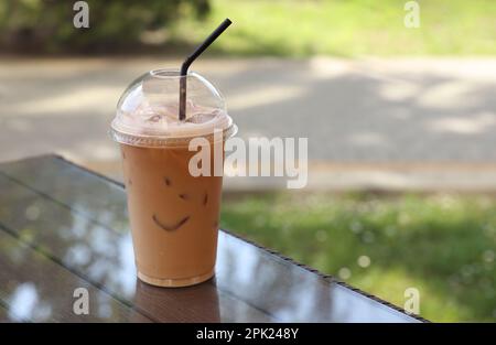 iced latte with straw in plastic cup on wood table in coffee shop,cafe  leisure lifestyle., Stock image