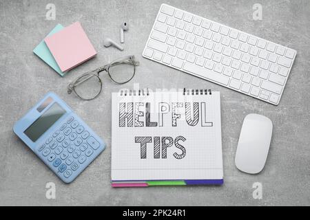 Flat lay composition with text Helpful Tips in notebook on grey table Stock Photo