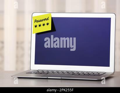 Sticky note with password on laptop indoors. Space for text Stock Photo