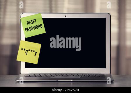 Sticky notes with passcode and phrase Reset Password on laptop. Space for text Stock Photo