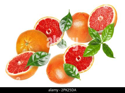 Tasty ripe grapefruits and green leaves falling on white background Stock Photo