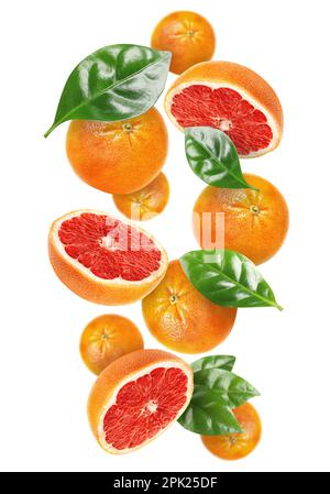 Tasty ripe grapefruits and green leaves falling on white background Stock Photo