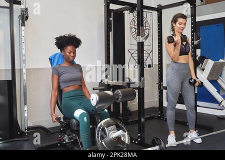 Two sporty women working out in the gym. Sport and healthy lifestyle concept. Stock Photo