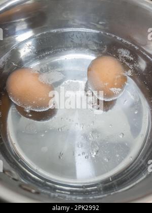 Eggs boiling in boiling water in saucepan Stock Photo