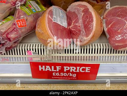 Legs of lamb on offer, meat refrigerator at Sainsburys supermarket - half price at £6.50 per KG -Increasing unaffordability of meat due to inflation Stock Photo