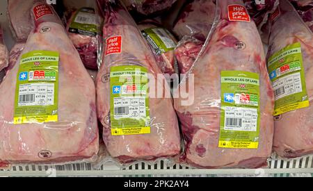 Legs of lamb on offer, meat refrigerator at Sainsburys supermarket - half price at £6.50 per KG -Increasing unaffordability of meat due to inflation Stock Photo