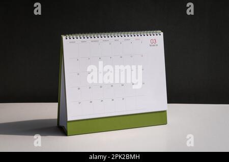 Standing desk calendar March on white table and black background. Stock Photo