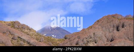 Panoramica dall'alto del cratere del vulcano Etna durante giornata di sole in estate e cielo blu con emissione di vapore - Stock Photo