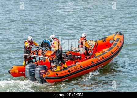 Life boat crew exercising in a dingy at Poole Harbour, Dorset, England Stock Photo