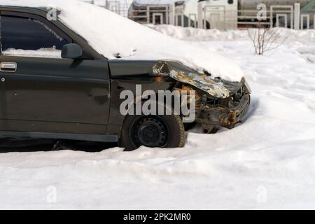 Driver lost control of the car on a slippery road in icy conditions. An old car in winter after an accident Stock Photo